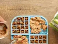 Préparation d'un tapis de léchage pour chien : croquettes et pâtée sont disposées dans les compartiments.