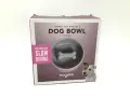 Boîte de jeu gamelle pour chien Magisso, avec un design en forme d'os pour ralentir l'ingestion. Un chien joyeux regarde.