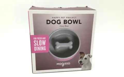 Boîte de jeu gamelle pour chien Magisso, avec un design en forme d'os pour ralentir l'ingestion. Un chien joyeux regarde.