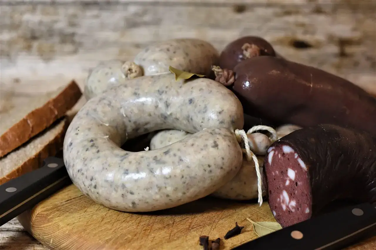 Boudin noir pour chien et ses compagnons, des saucisses savoureuses sur une planche en bois.